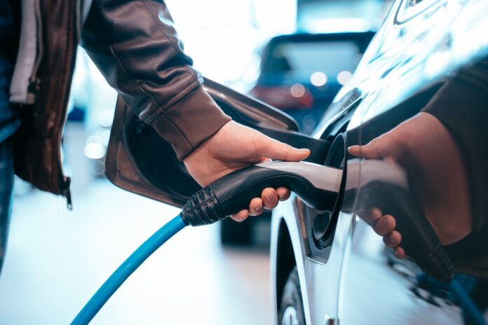 eternalyte batterien 24m technologie Schließt sich die ein Mann der ein Ladegerät für Elektroautos in der hand hat das mit dem Elektroauto verbunden ist